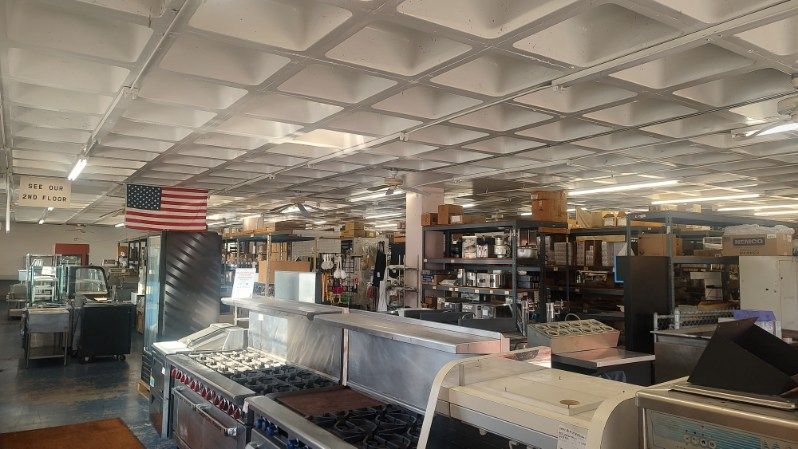 A large kitchen with a lot of appliances and an american flag hanging from the ceiling.