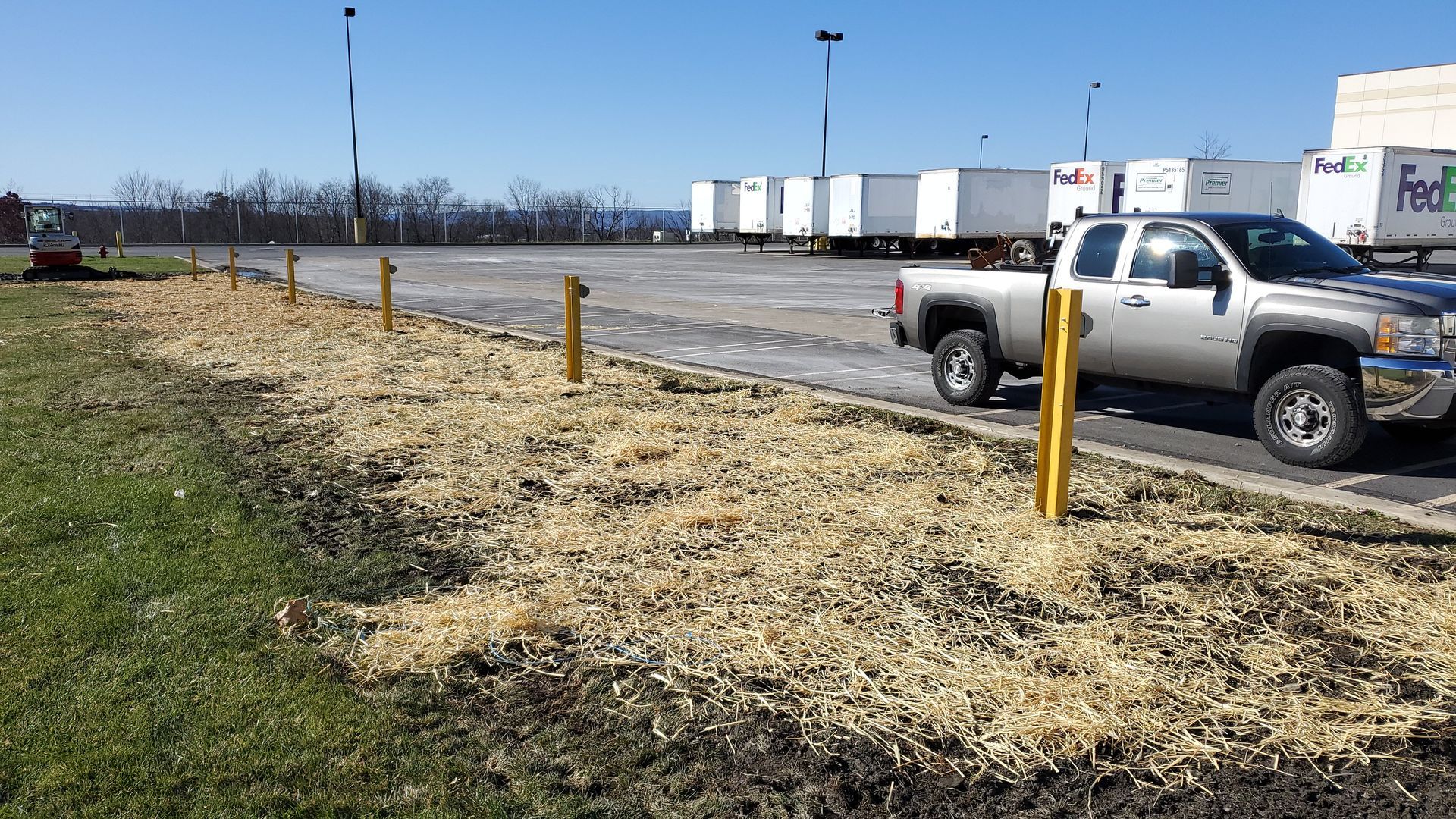 A truck is parked in a parking lot next to a fence.