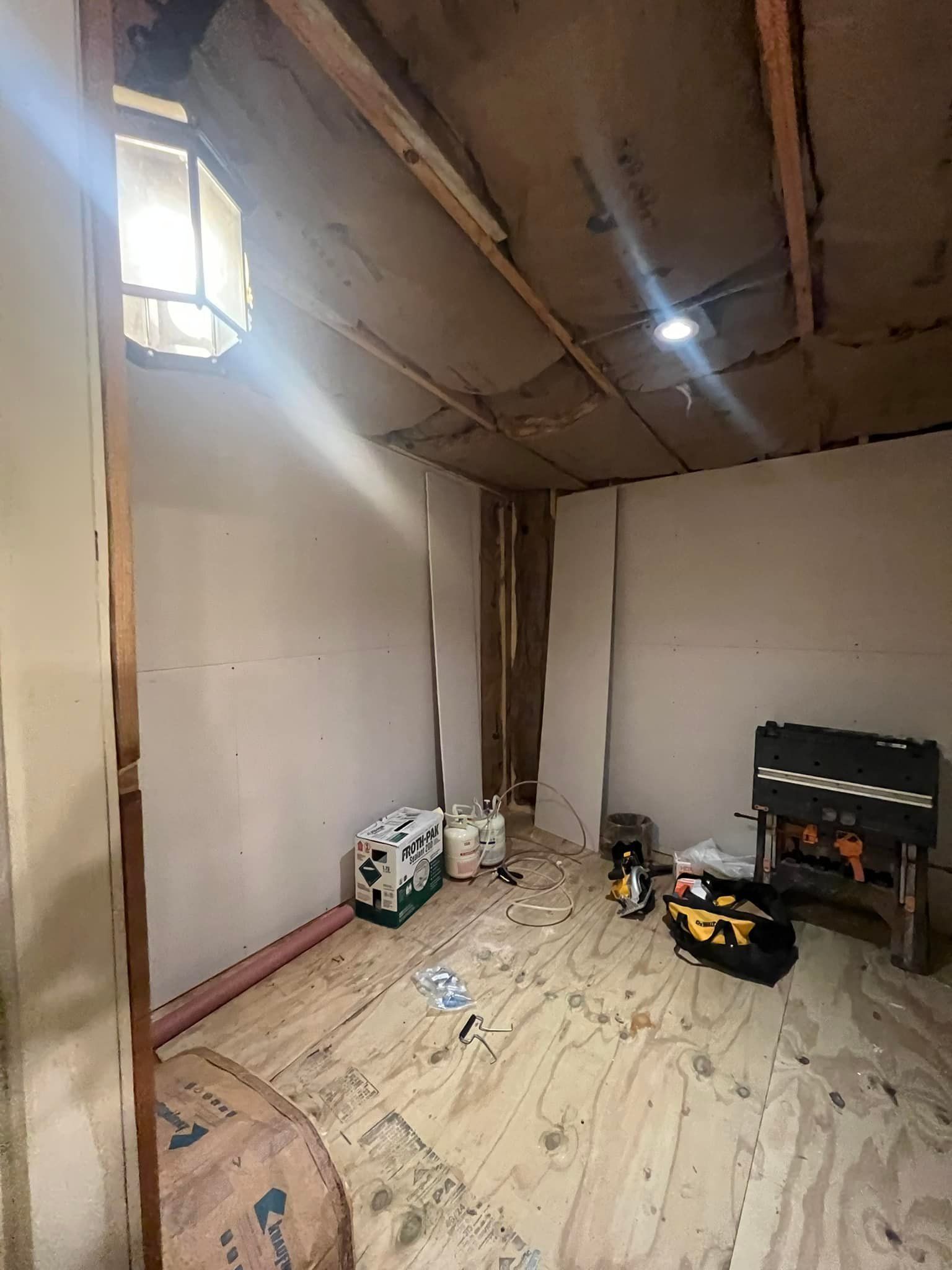 Interior view of a room under construction with unfinished walls and ceiling.