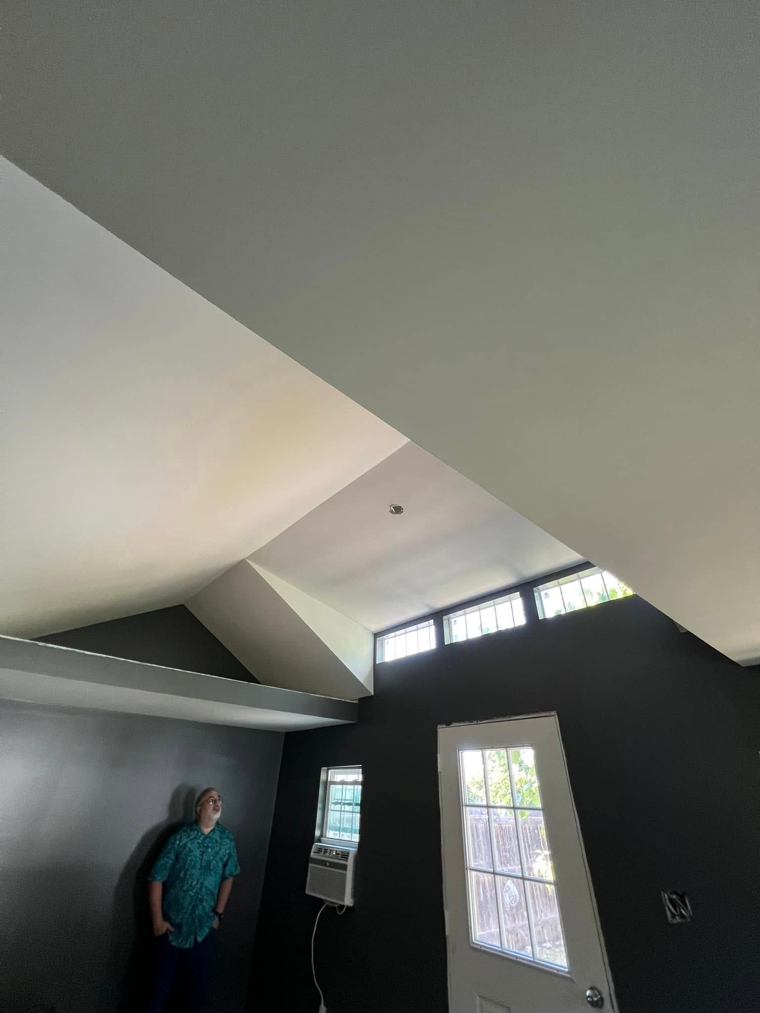 Person looking up in a room with a high, angled ceiling.