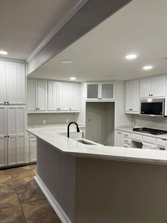 A light-colored garage interior. A water softener is visible against the back wall, and a door frame is on the left.