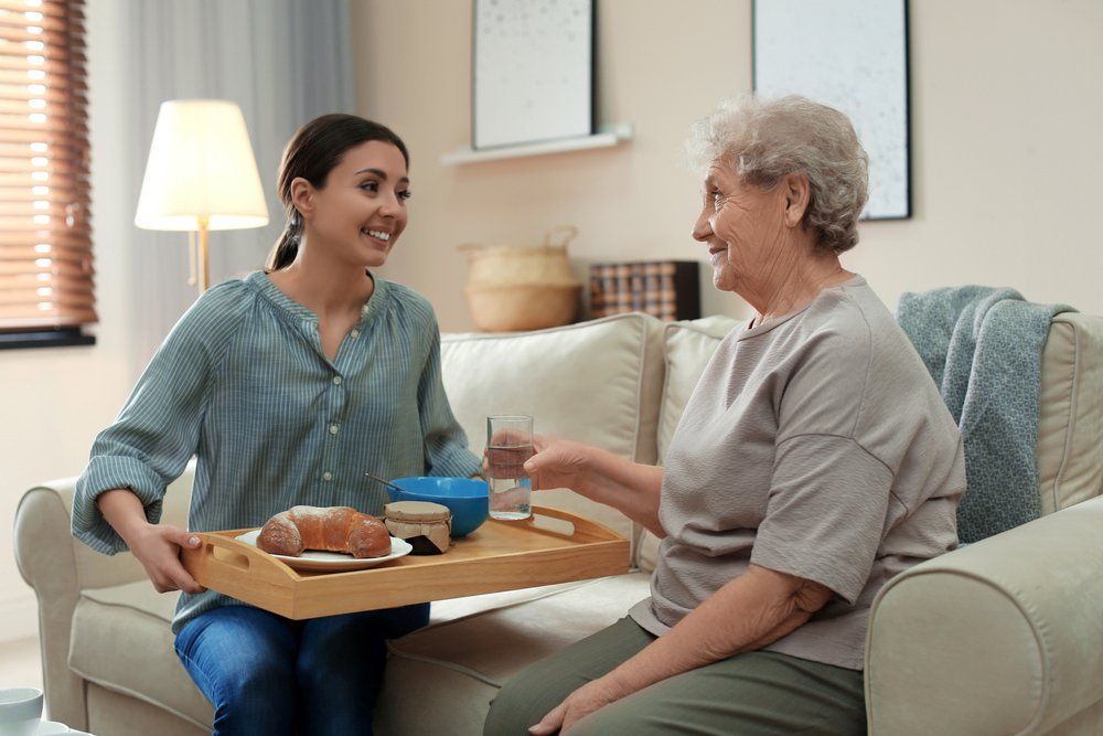 Young Woman Giving Foods to Old Lady - Catering Equipment In Mackay, QLD