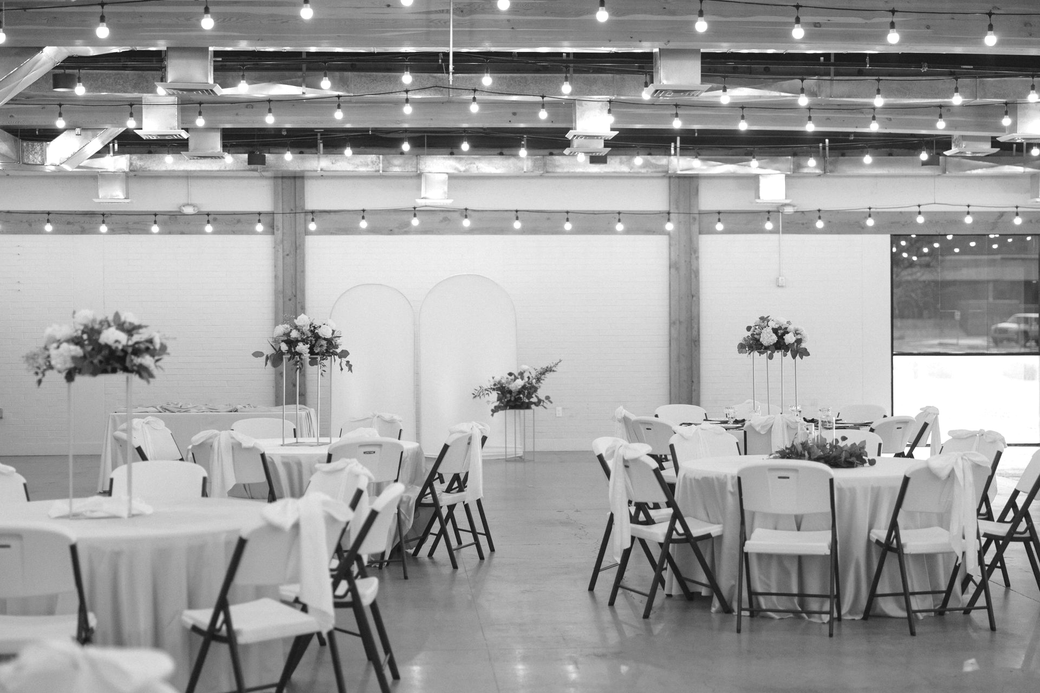 A large empty room with tables and chairs in it.