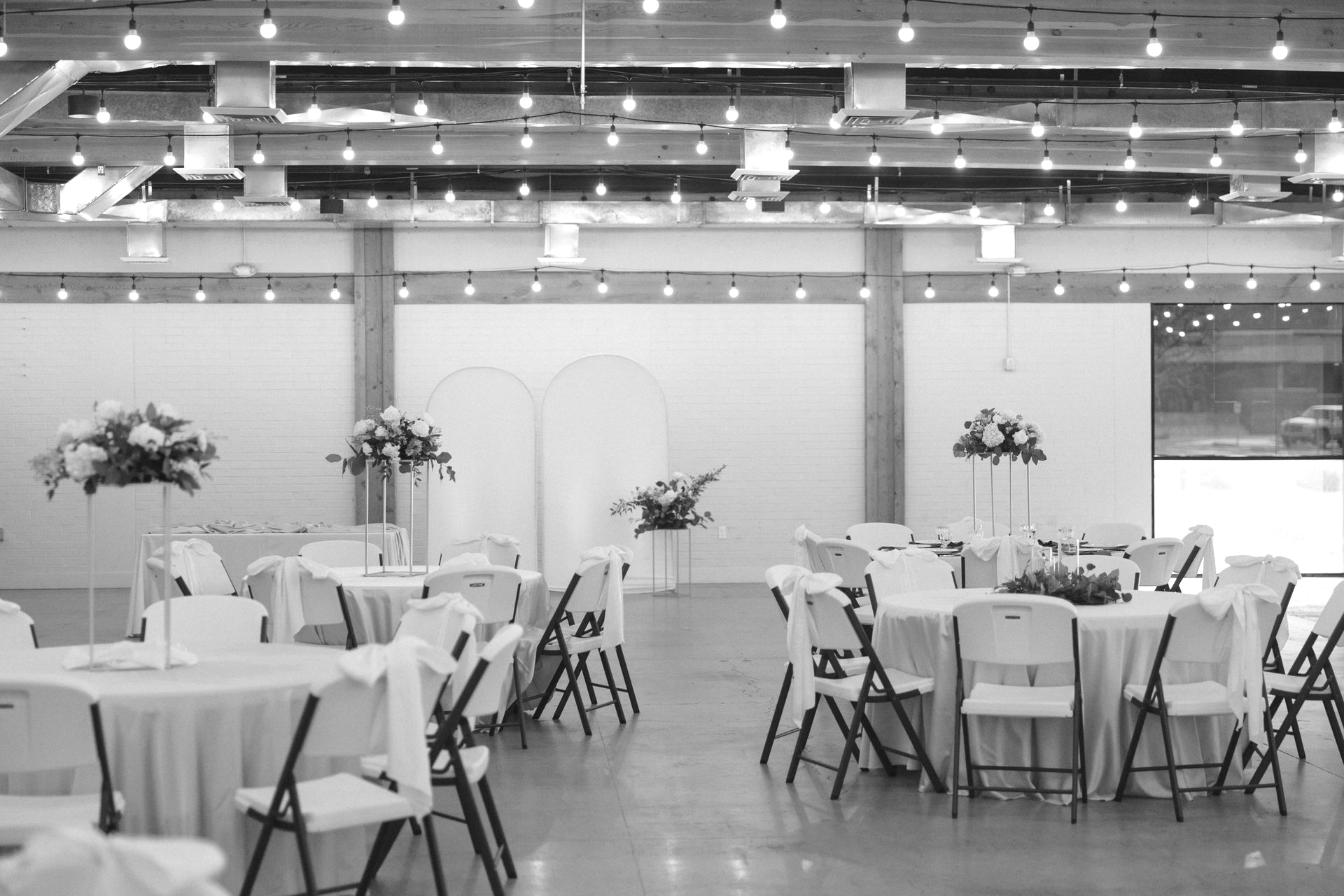 A large empty room with tables and chairs in it.
