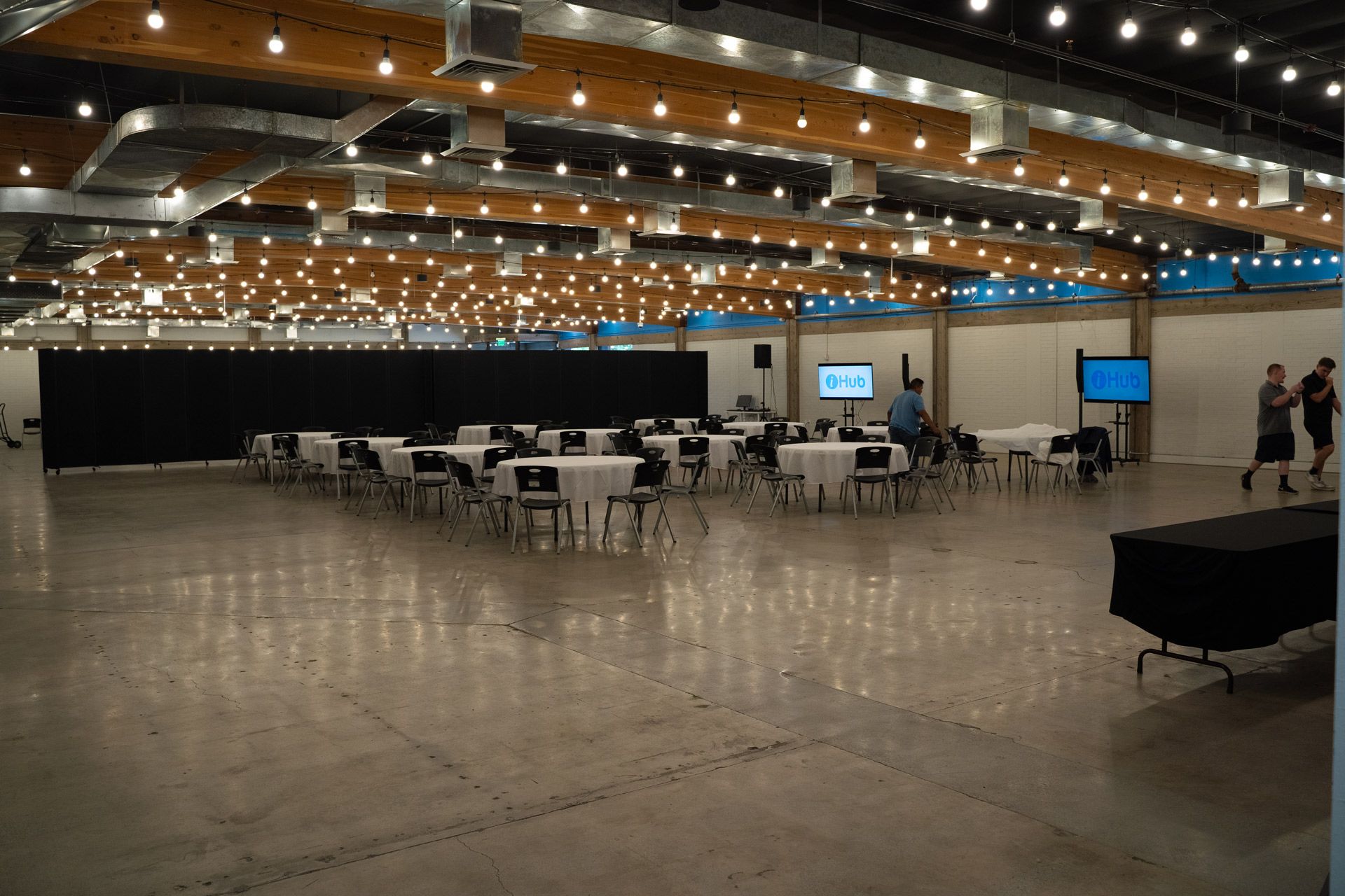 A large empty room with tables and chairs in it.