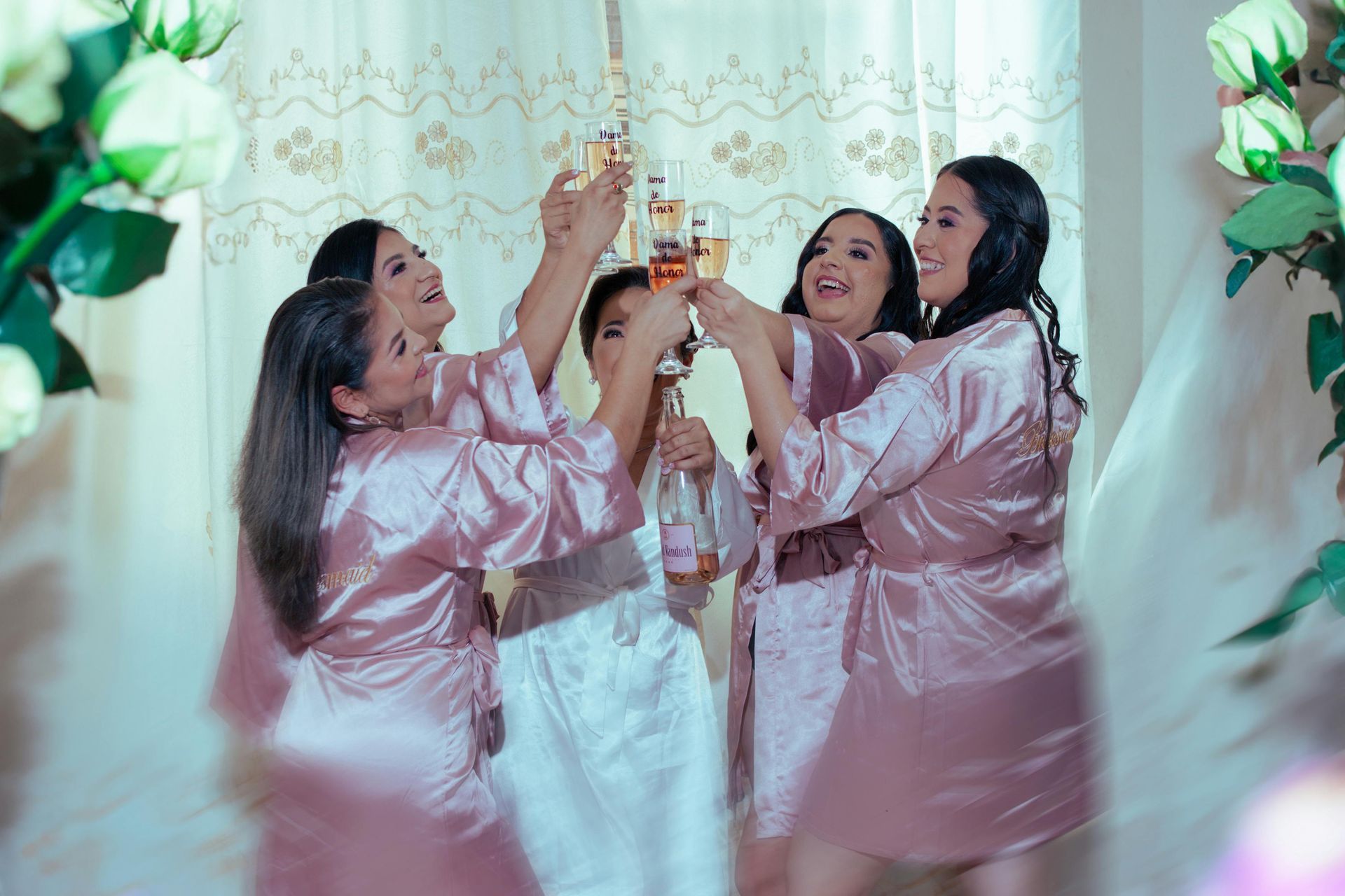 A bride and her bridesmaids are toasting with champagne.