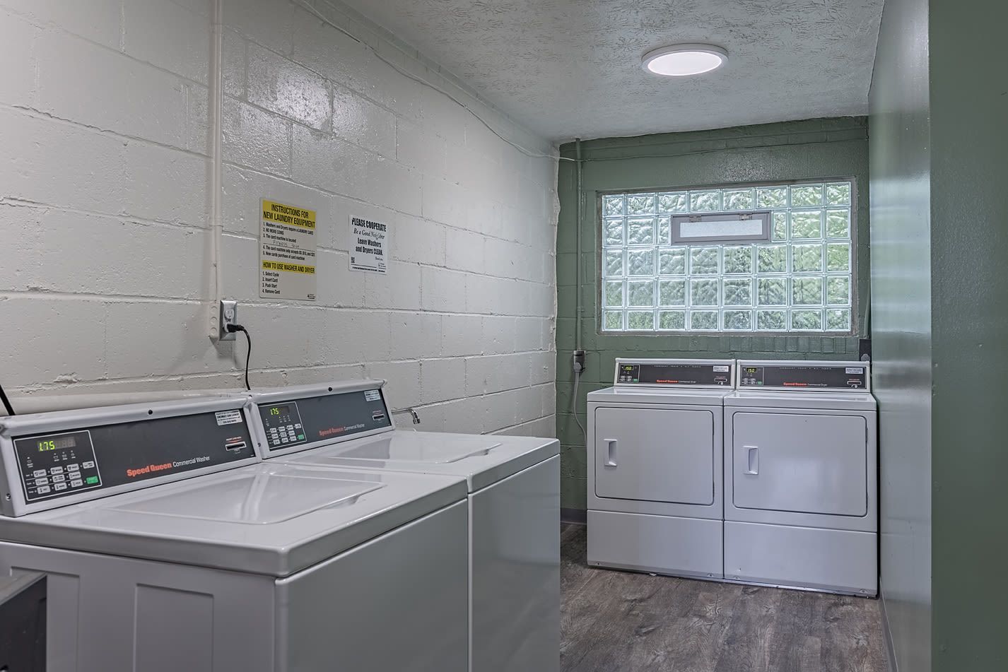 Laundry room with several top-loading washers and front-loading dryers.