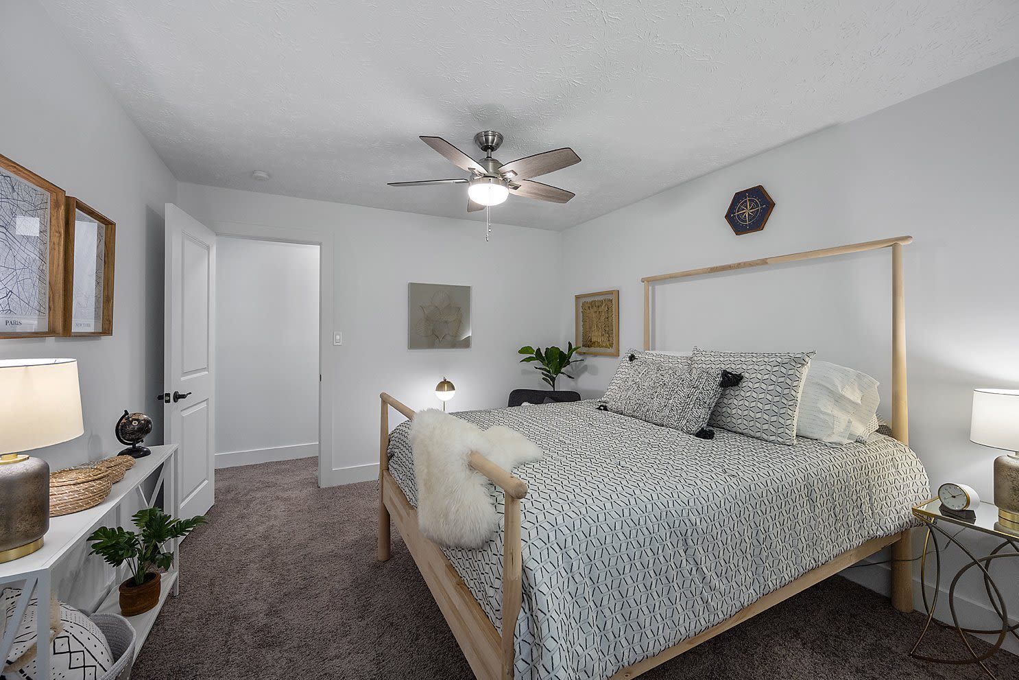 Bedroom interior in a modern apartment with a wooden bed frame, two nightstands, and soft lighting.