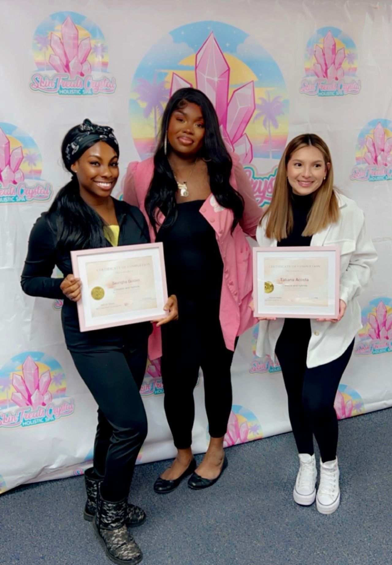 Three women are standing next to each other holding certificates.