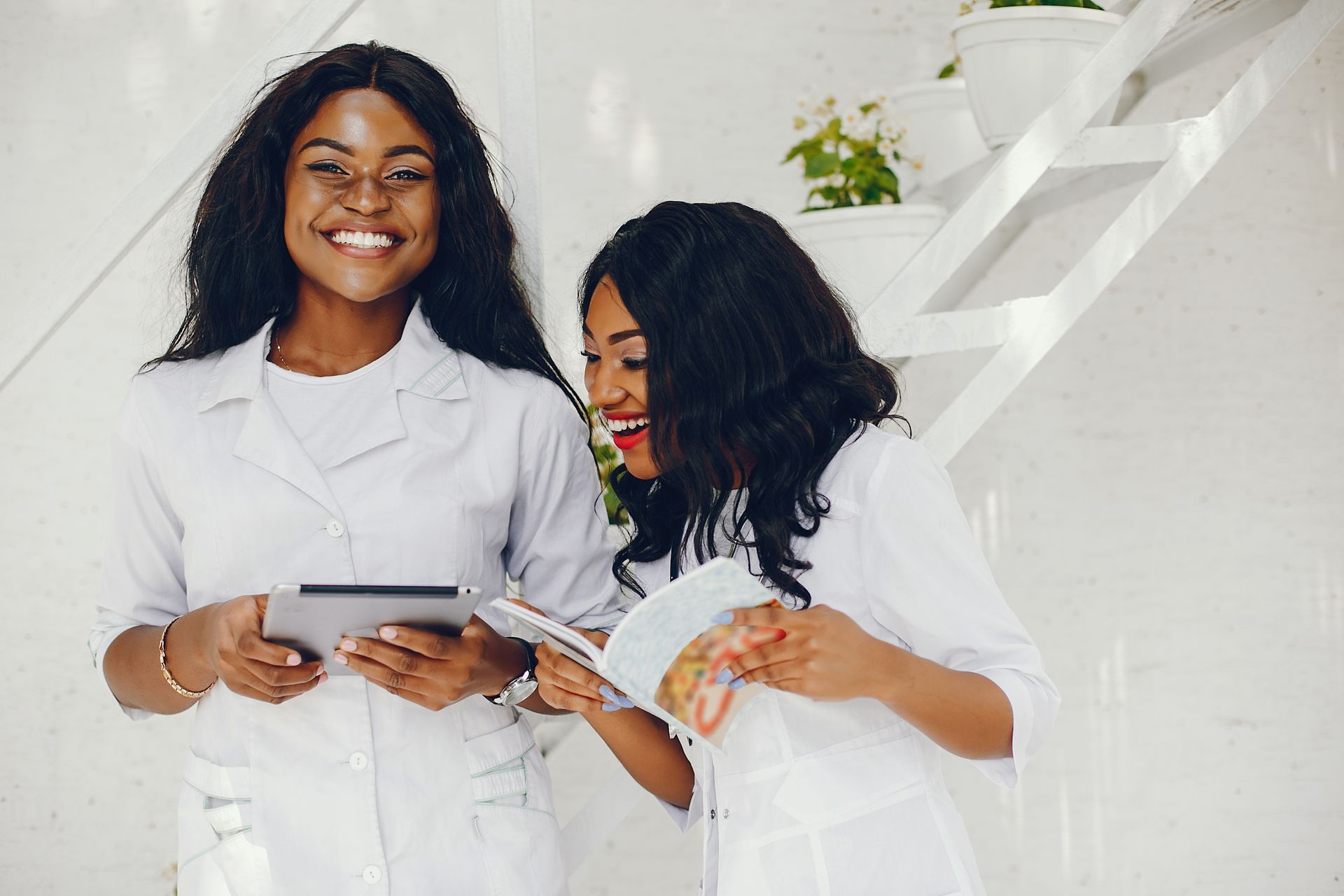 Two women are looking at a tablet together.