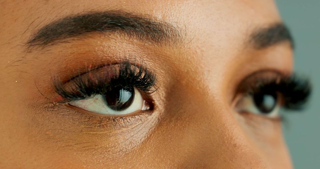 A woman is getting eyelash extensions in a beauty salon.