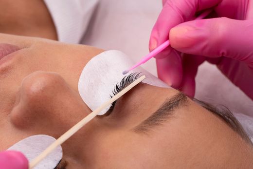 A woman is getting her eyelashes done at a beauty salon.