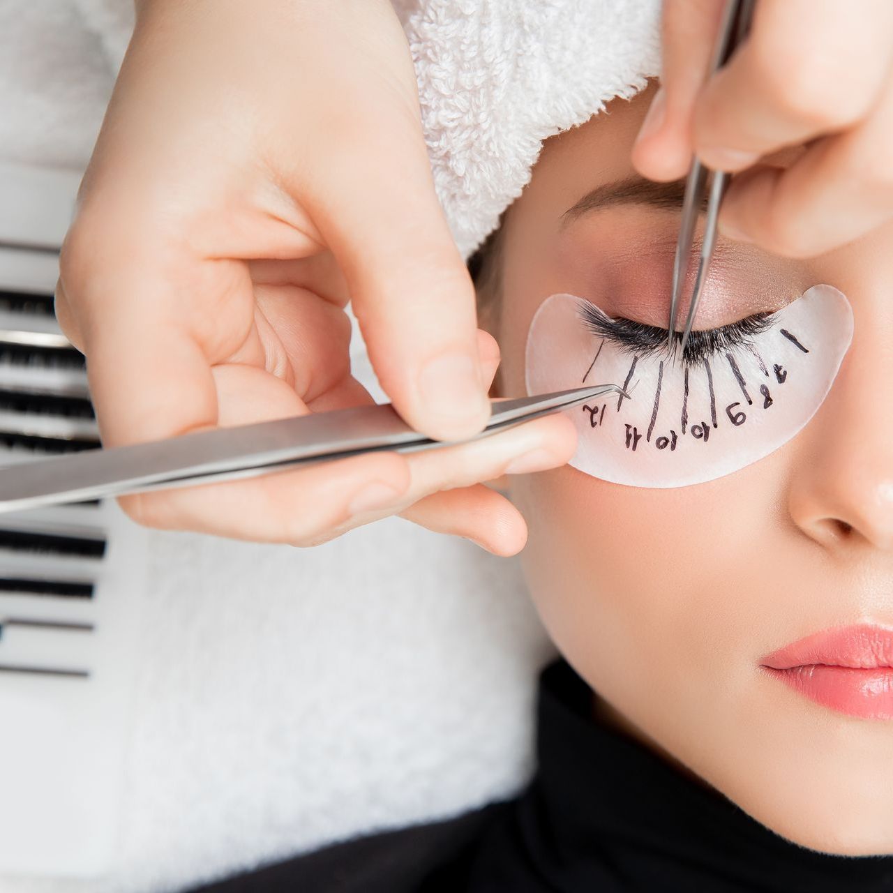 A woman is getting her eyelashes done at a beauty salon.