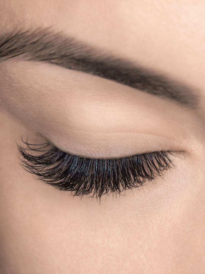 A close up of a woman 's eye with long eyelashes.