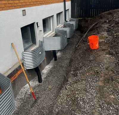 Une pelle et un seau sont posés par terre devant un bâtiment.