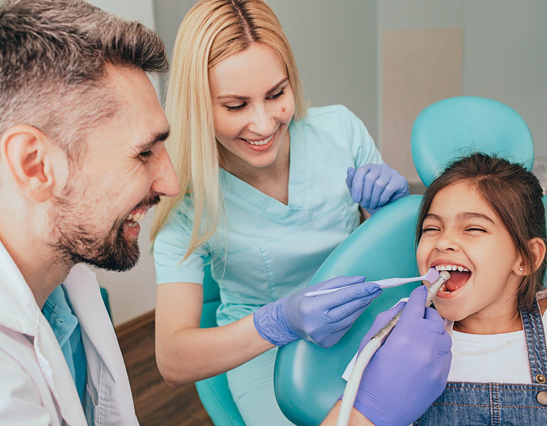 Two Dentist Cleaning the Teeth of a Child — Chicago Heights, IL — Midtown Dental Clinic