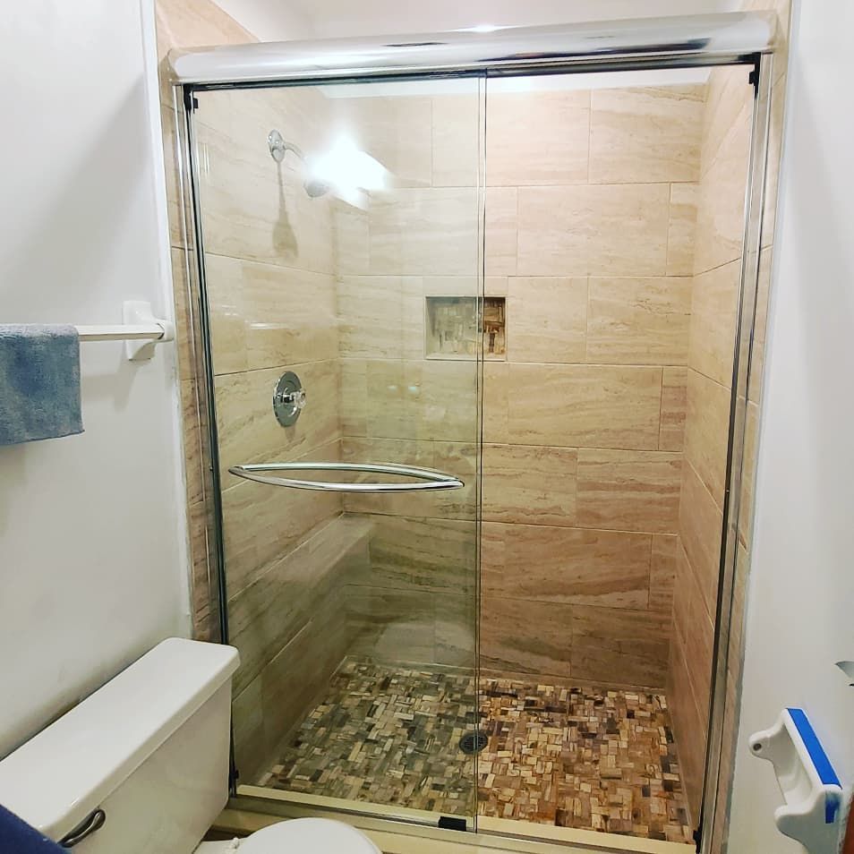 A bathroom with a sliding glass shower door and a toilet.