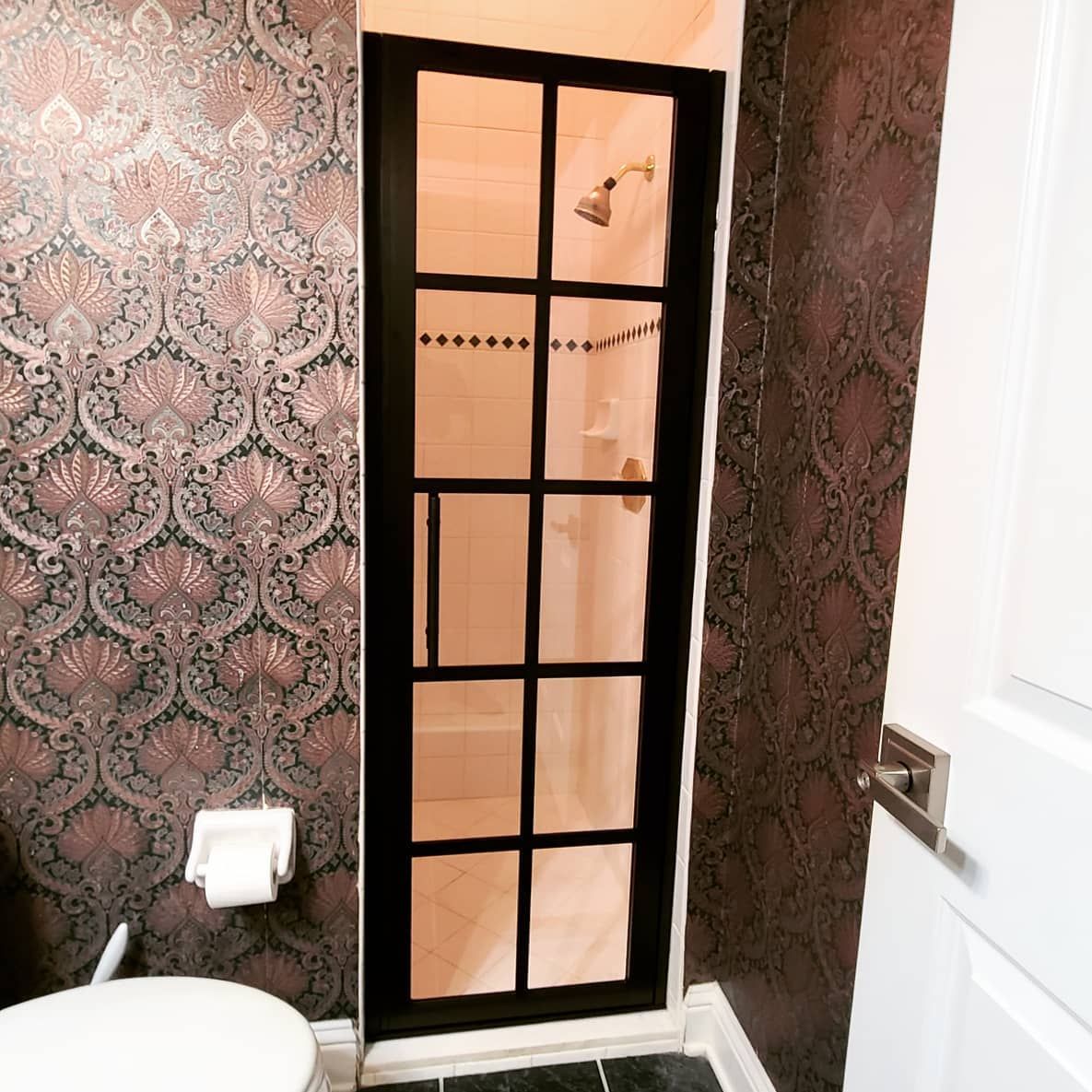 A bathroom with a toilet and a walk in shower