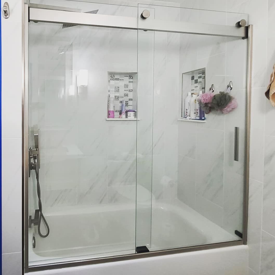 A bathroom with a bathtub and a glass shower door