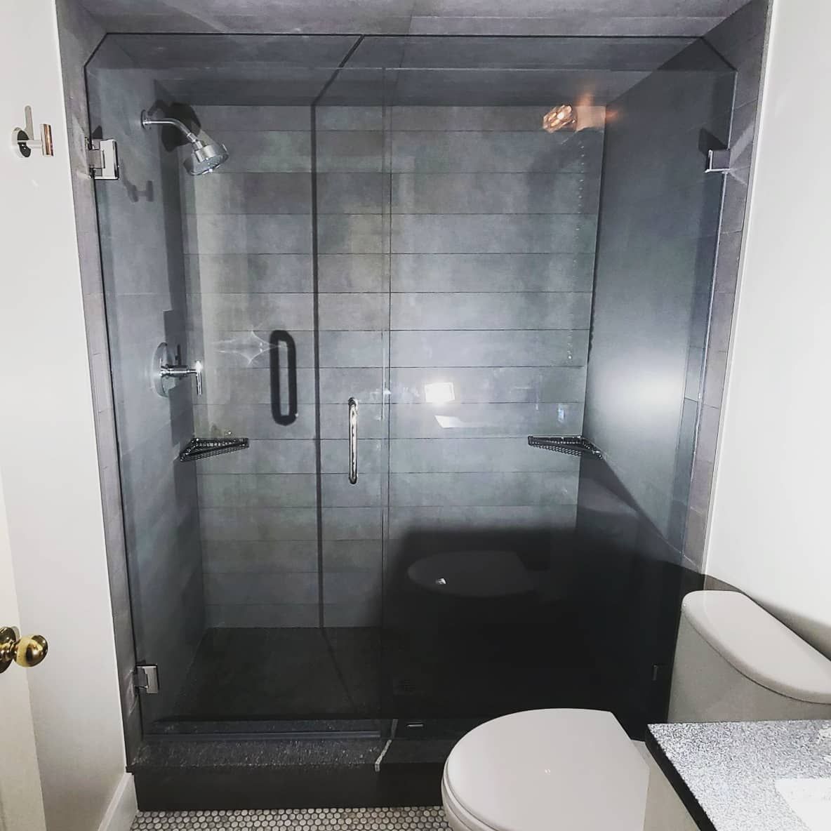 A bathroom with a toilet and a glass shower door