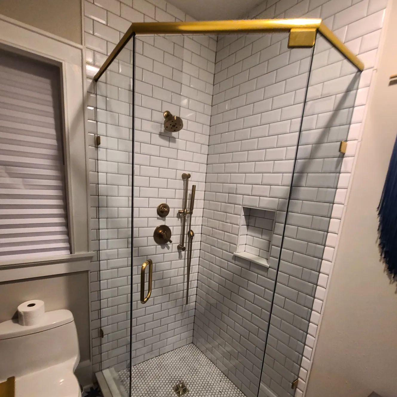 A bathroom with a toilet and a shower with a glass door