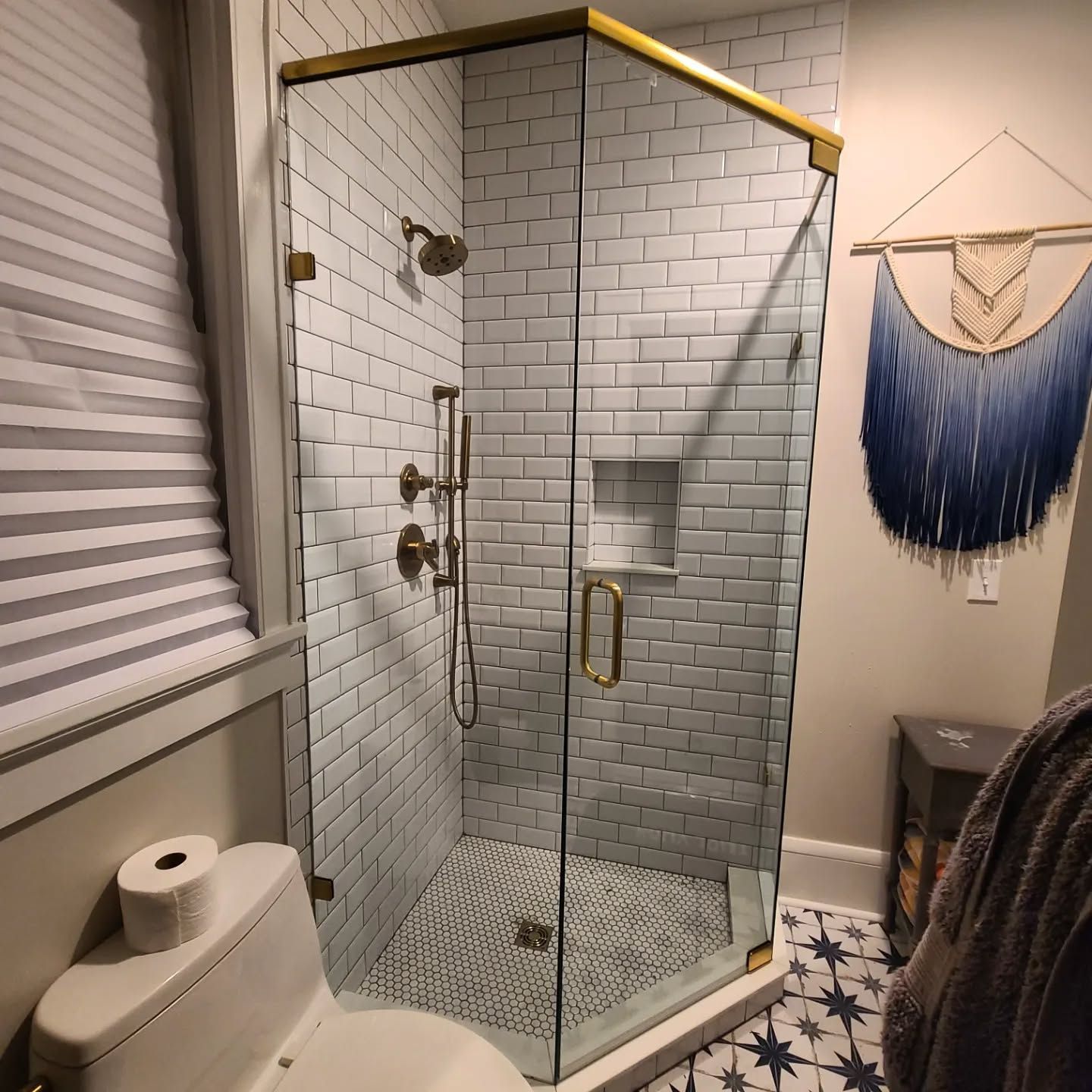 A bathroom with a toilet and a shower with a glass door.
