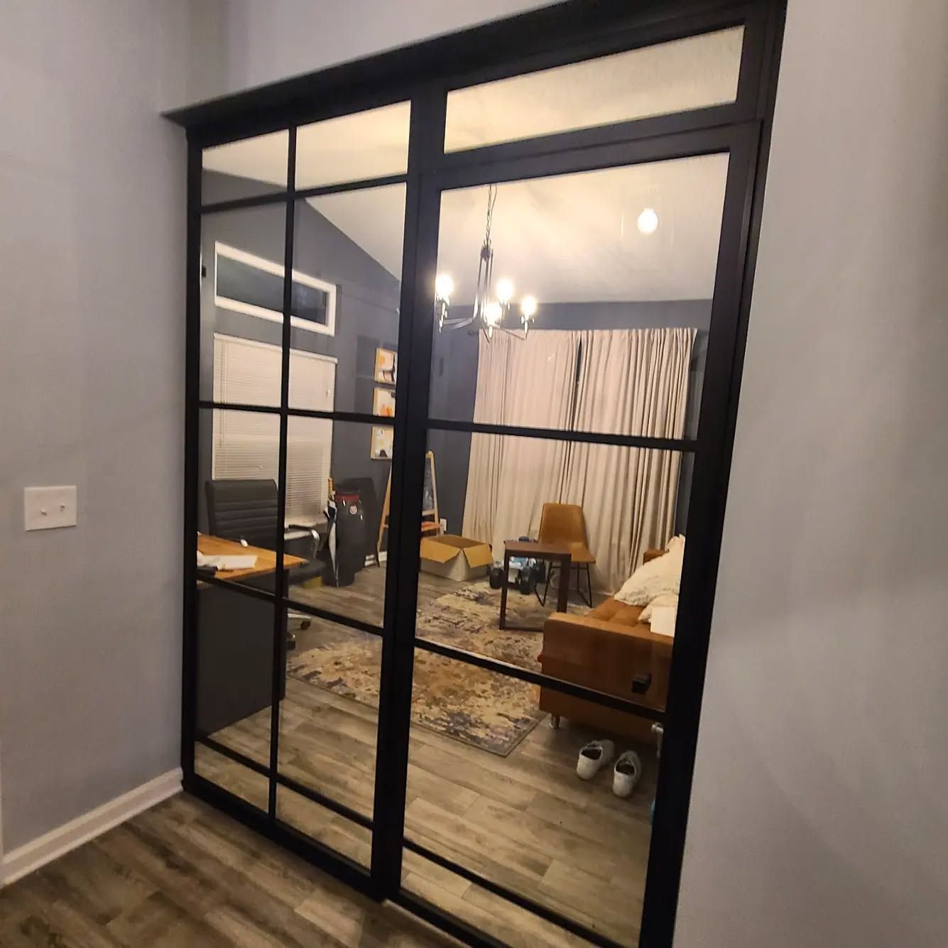 A living room with a couch and chairs behind a sliding glass door
