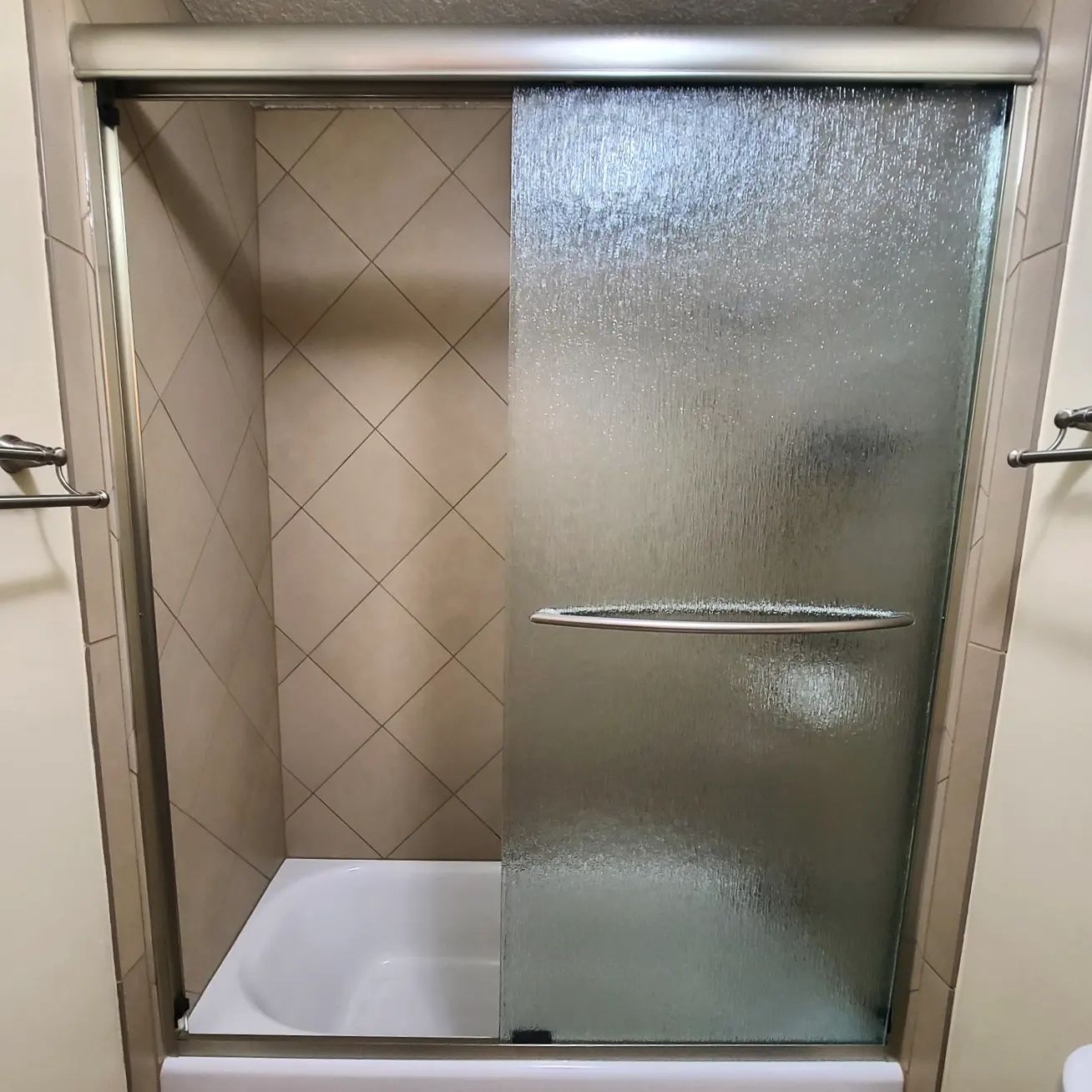 A bathroom with a sliding glass shower door