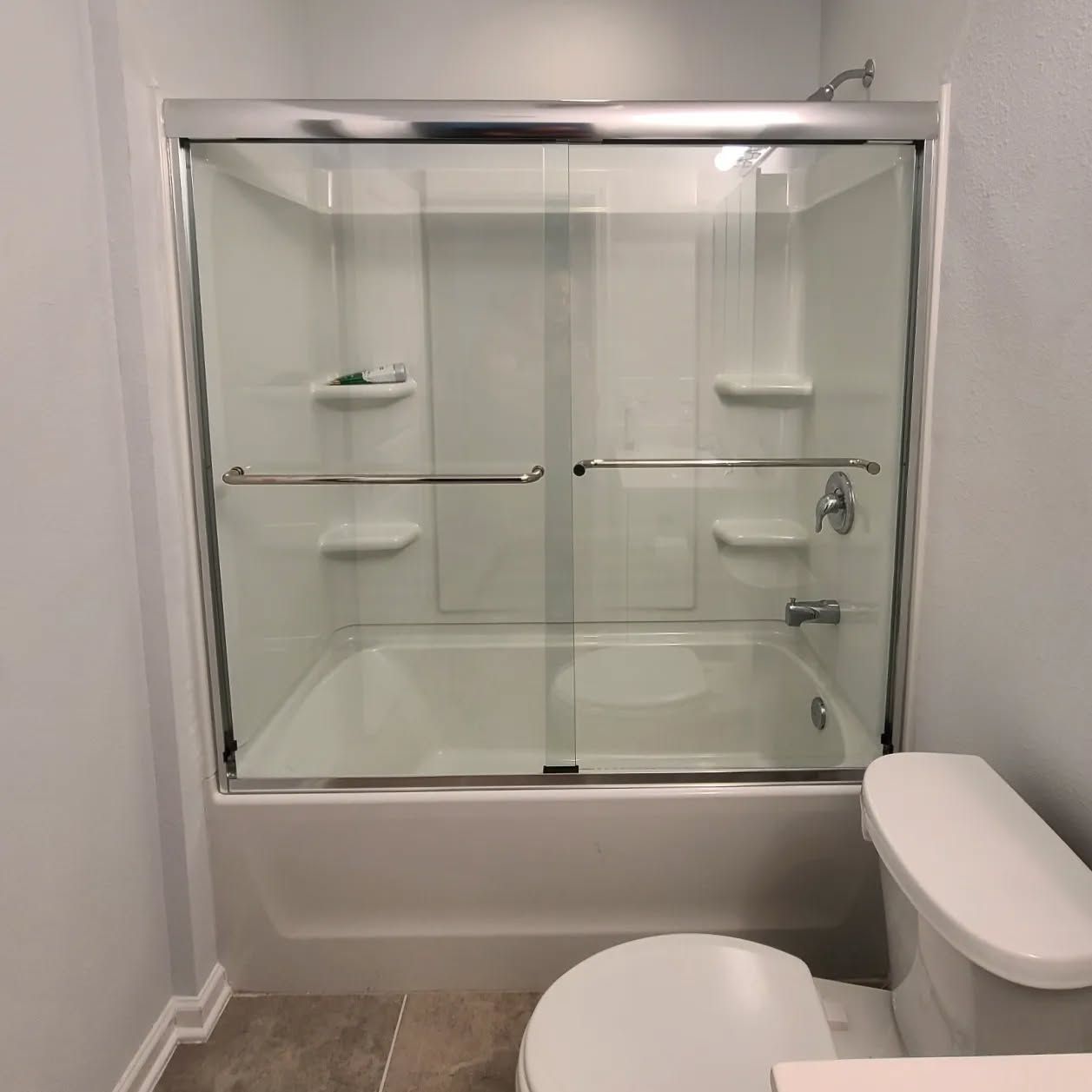A bathroom with a sliding glass shower door