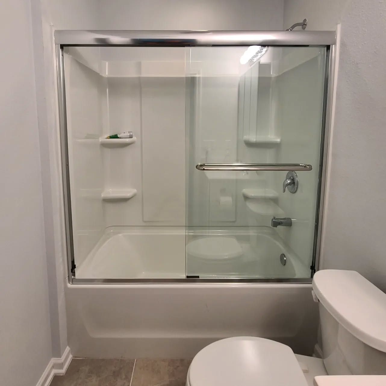 A bathroom with a sliding glass shower door