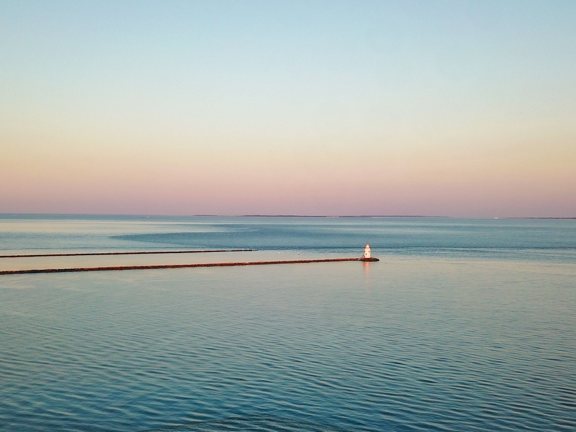 A large body of water with a lighthouse in the distance