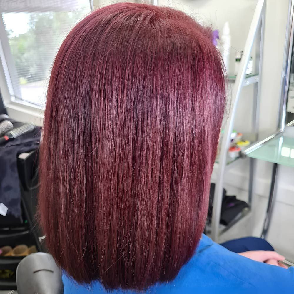 A Woman With Red Hair is Sitting in a Chair in a Salon — Lush Hair Studio in Tumbi Umbi, NSW
