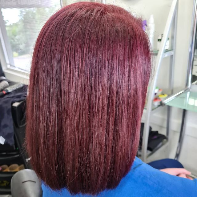 A Woman With Red Hair is Sitting in a Chair in a Salon — Lush Hair Studio in Tumbi Umbi, NSW