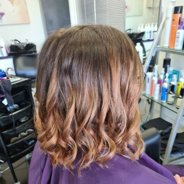 A Woman is Getting Her Hair Cut in a Salon — Lush Hair Studio in Tumbi Umbi, NSW