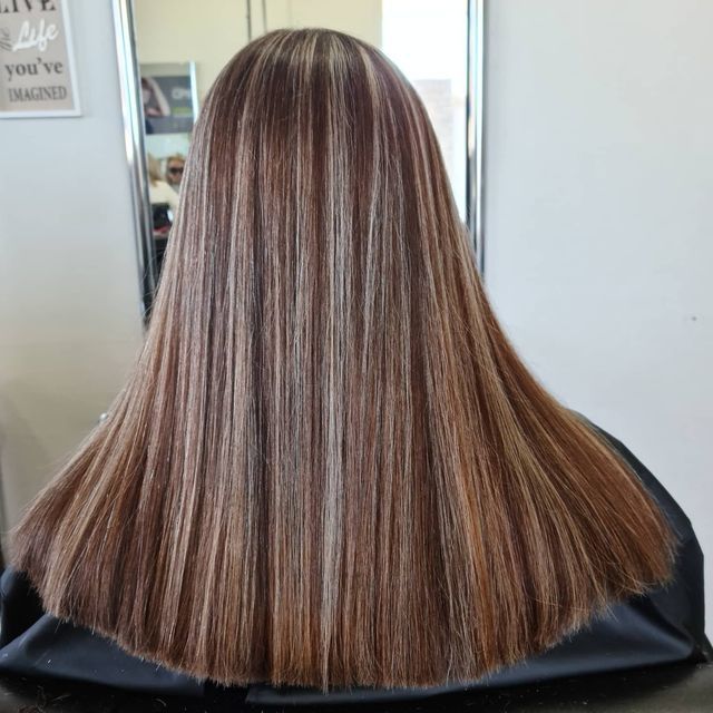 A Woman With Long Brown Hair is Sitting in Front of a Mirror — Lush Hair Studio in Tumbi Umbi, NSW