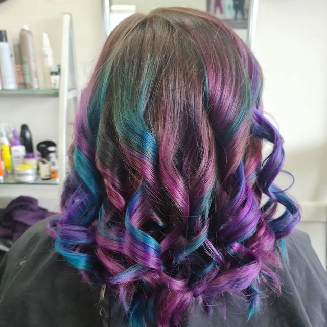 A Woman With Purple and Blue Hair is Sitting in a Chair in a Salon — Lush Hair Studio in Tumbi Umbi, NSW
