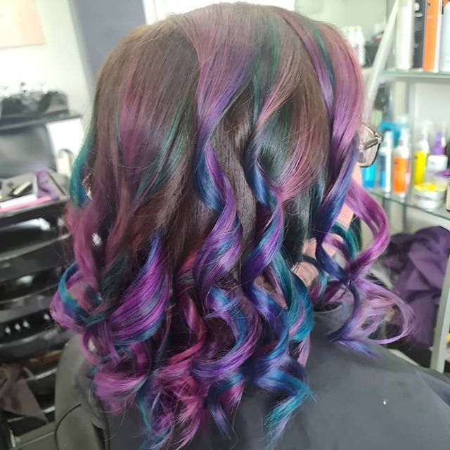 A Woman With Purple and Blue Hair is Sitting in a Chair in a Salon — Lush Hair Studio in Tumbi Umbi, NSW