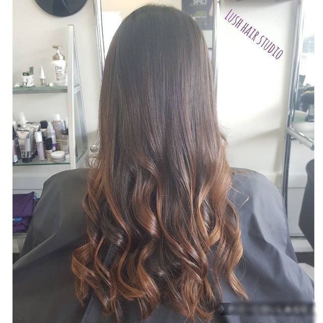 A Woman With Long Hair is Sitting in a Chair at Lush Hair Studio — Lush Hair Studio in Tumbi Umbi, NSW