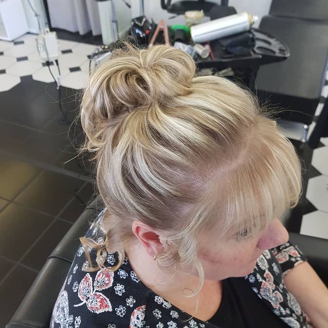 A Woman is Sitting in a Chair With Her Hair in a Bun — Lush Hair Studio in Tumbi Umbi, NSW