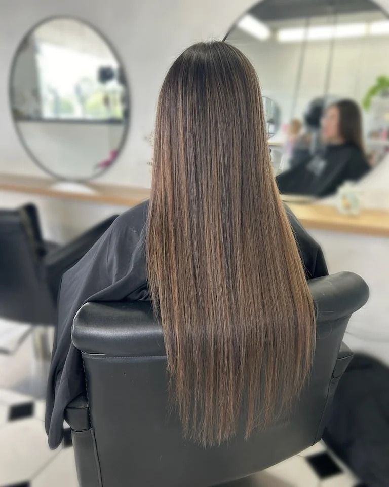 A Woman With Long Hair is Sitting in a Chair at a Hair Salon — Lush Hair Studio in Tumbi Umbi, NSW