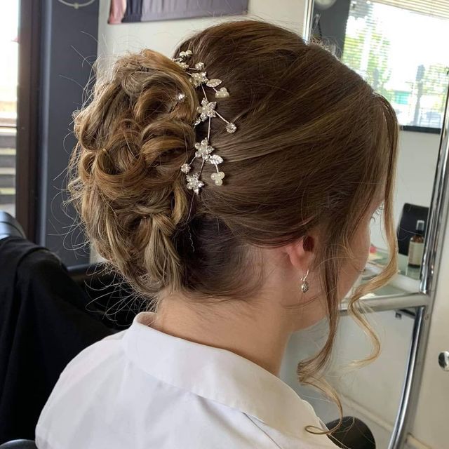A Woman is Wearing a Bun With Flowers in Her Hair — Lush Hair Studio in Tumbi Umbi, NSW