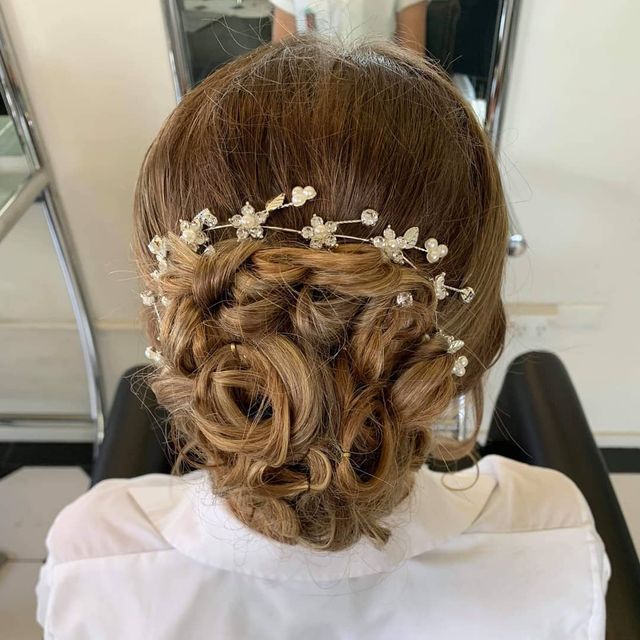 A Woman is Sitting in a Chair With Her Hair in a Bun — Lush Hair Studio in Tumbi Umbi, NSW