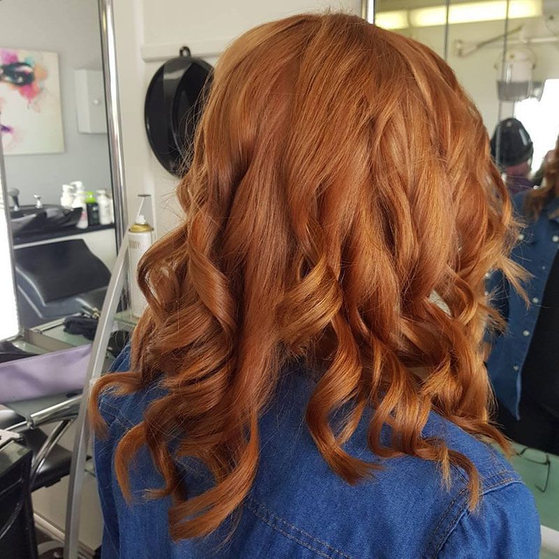 A Woman With Red Hair is Standing in Front of a Mirror — Lush Hair Studio in Tumbi Umbi, NSW