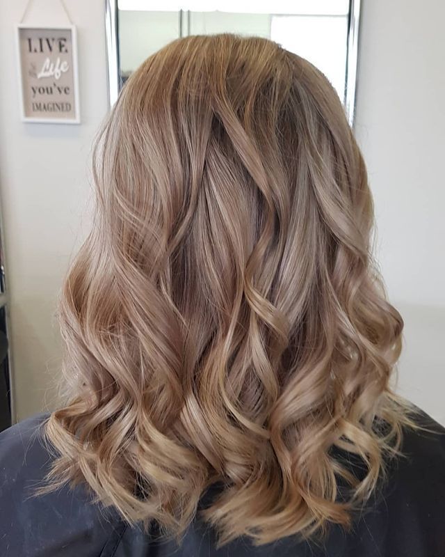 A Woman With Blonde Hair is Sitting in Front of a Mirror — Lush Hair Studio in Tumbi Umbi, NSW
