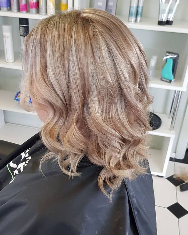 A Woman With Blonde Hair is Sitting in a Chair in a Salon — Lush Hair Studio in Tumbi Umbi, NSW
