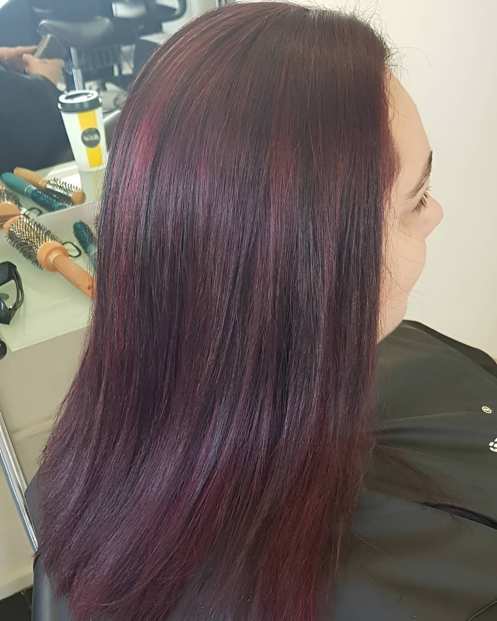 A Woman With Purple Hair is Sitting in a Chair in a Salon — Lush Hair Studio in Tumbi Umbi, NSW