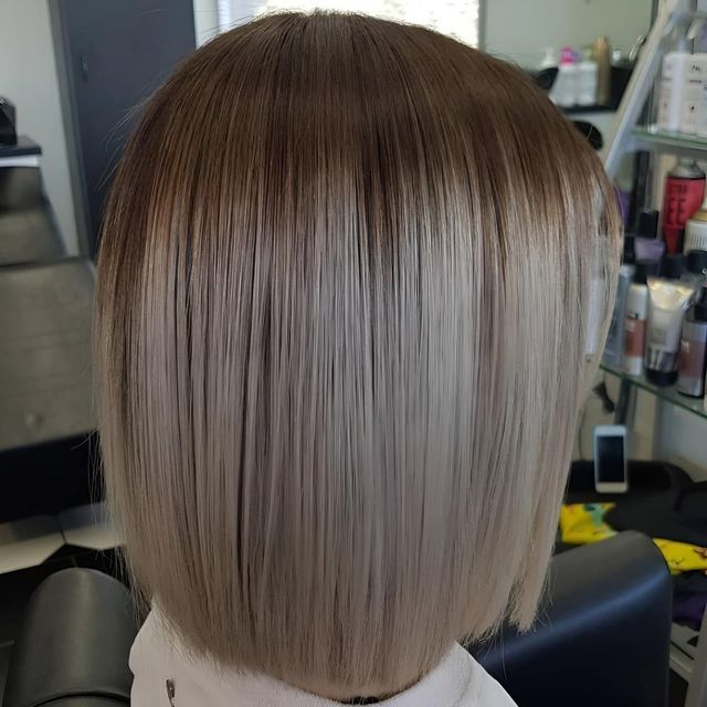 A Woman is Getting Her Hair Cut in a Salon — Lush Hair Studio in Tumbi Umbi, NSW