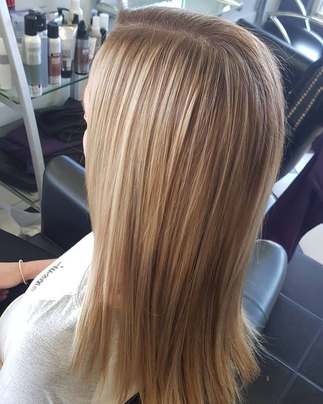 A Woman With Blonde Hair is Sitting in a Chair in a Salon — Lush Hair Studio in Tumbi Umbi, NSW