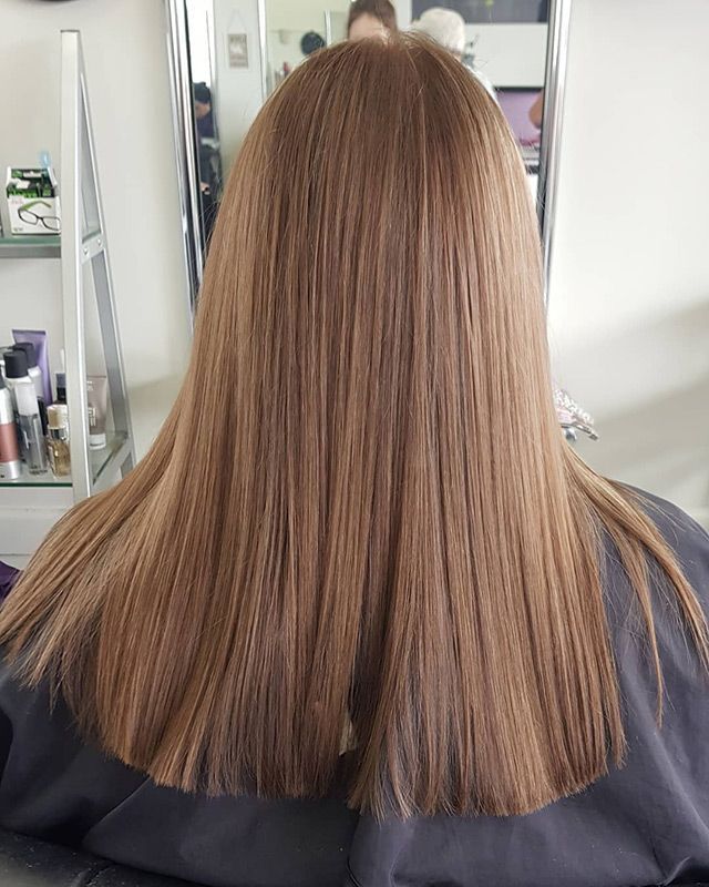 A Woman With Long Brown Hair is Sitting in Front of a Mirror — Lush Hair Studio in Tumbi Umbi, NSW