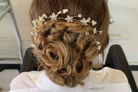 A Woman is Wearing a Bun With Flowers in Her Hair — Lush Hair Studio in Tumbi Umbi, NSW